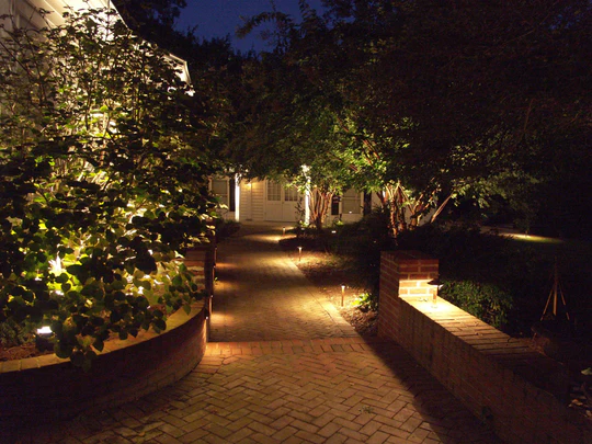 Sterling landscape lighting around a curved walkway and garden bed